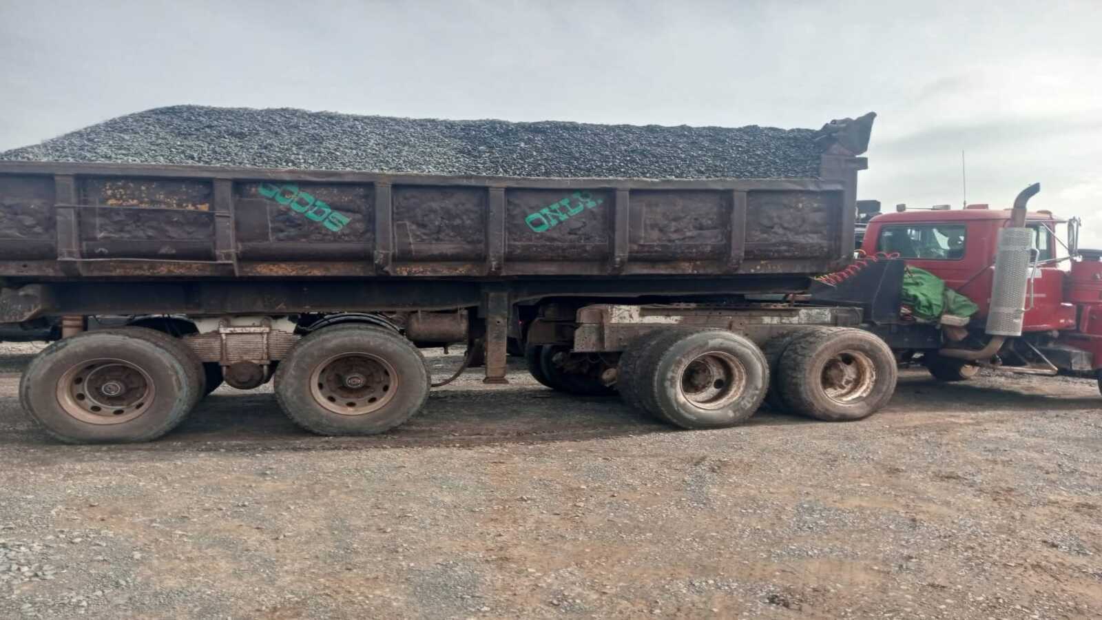 Businessman shaking hands with fleet of trucks in the background